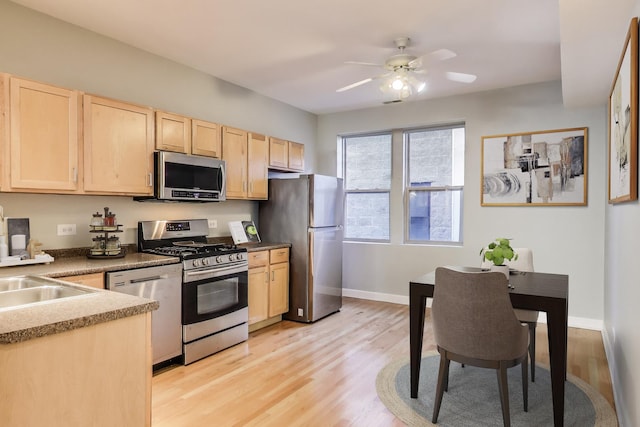 kitchen featuring light brown cabinetry, sink, light hardwood / wood-style flooring, appliances with stainless steel finishes, and ceiling fan