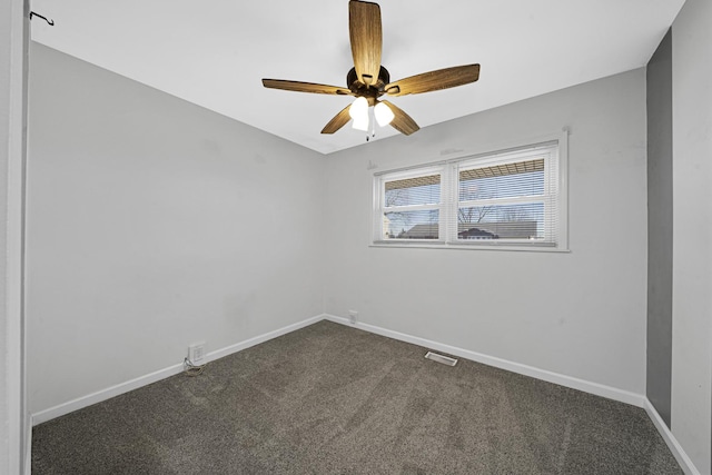 empty room featuring ceiling fan and dark colored carpet