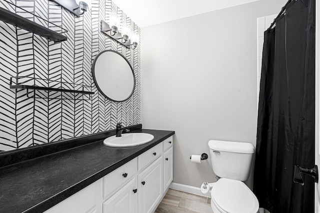 bathroom with hardwood / wood-style flooring, vanity, a shower with shower curtain, and toilet