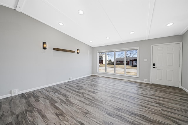 unfurnished living room featuring lofted ceiling and dark hardwood / wood-style flooring