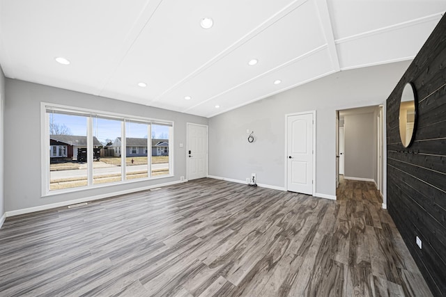 unfurnished living room featuring hardwood / wood-style flooring and lofted ceiling with beams