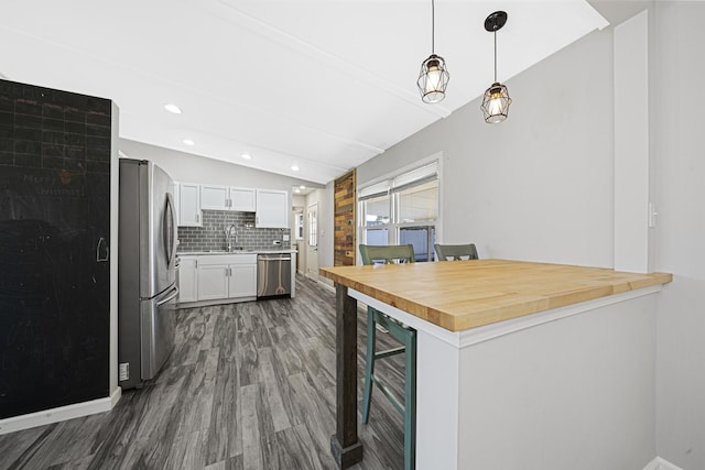 kitchen featuring sink, appliances with stainless steel finishes, hanging light fixtures, white cabinets, and beverage cooler