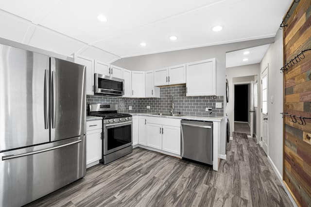 kitchen featuring appliances with stainless steel finishes, sink, decorative backsplash, and white cabinets