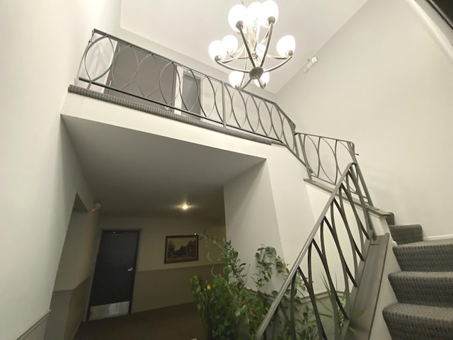 stairs with a notable chandelier and high vaulted ceiling