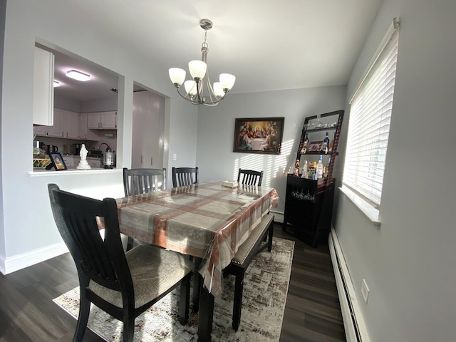 dining space with dark hardwood / wood-style flooring, baseboard heating, and an inviting chandelier