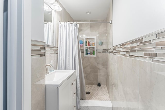 bathroom featuring vanity, tile walls, and a shower with curtain