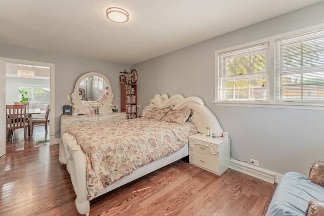 bedroom with hardwood / wood-style floors and a notable chandelier