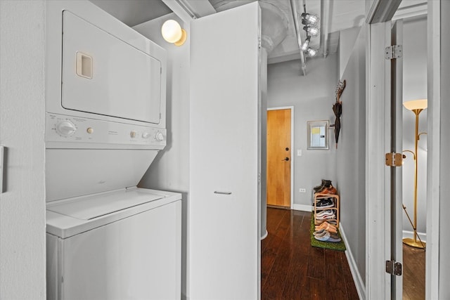 laundry area featuring dark wood-type flooring and stacked washer and dryer