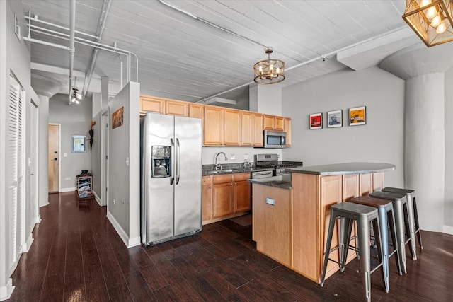 kitchen featuring a kitchen island, appliances with stainless steel finishes, decorative light fixtures, sink, and dark wood-type flooring