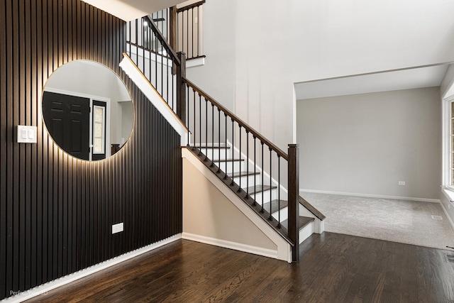 stairs with a high ceiling and wood-type flooring