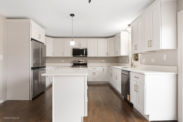 kitchen featuring sink, white cabinetry, decorative light fixtures, a center island, and appliances with stainless steel finishes