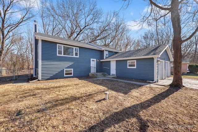 back of house featuring a garage and an outdoor structure