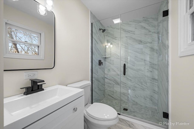 bathroom featuring vanity, toilet, and walk in shower