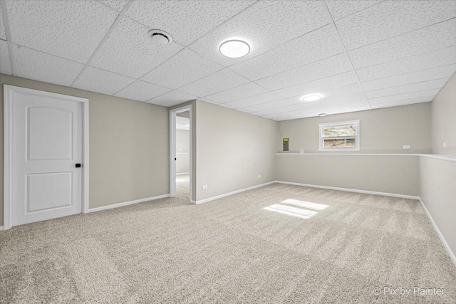 basement with carpet floors and a paneled ceiling