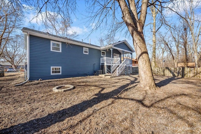 back of house featuring cooling unit, an outdoor fire pit, and covered porch