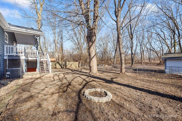 view of yard with central AC unit and an outdoor fire pit