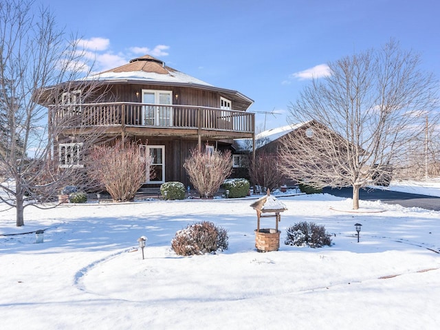 snow covered patio with a storage unit and a pergola