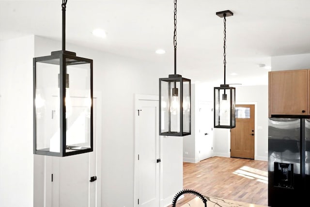 kitchen featuring hanging light fixtures, light brown cabinets, light hardwood / wood-style floors, and stainless steel fridge with ice dispenser