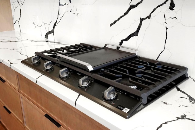 room details featuring tasteful backsplash and gas cooktop