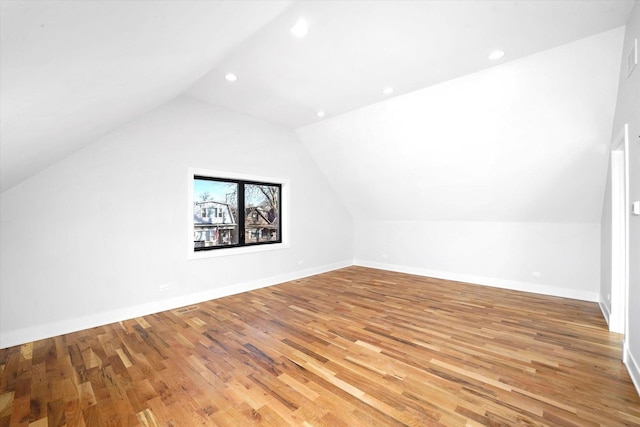 bonus room with wood-type flooring and vaulted ceiling