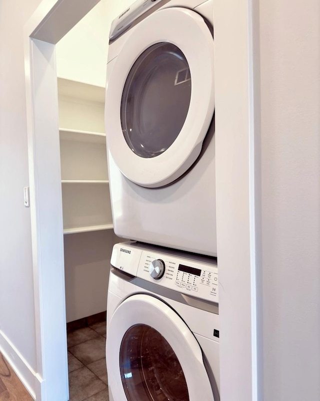 laundry room featuring tile patterned flooring and stacked washer / drying machine