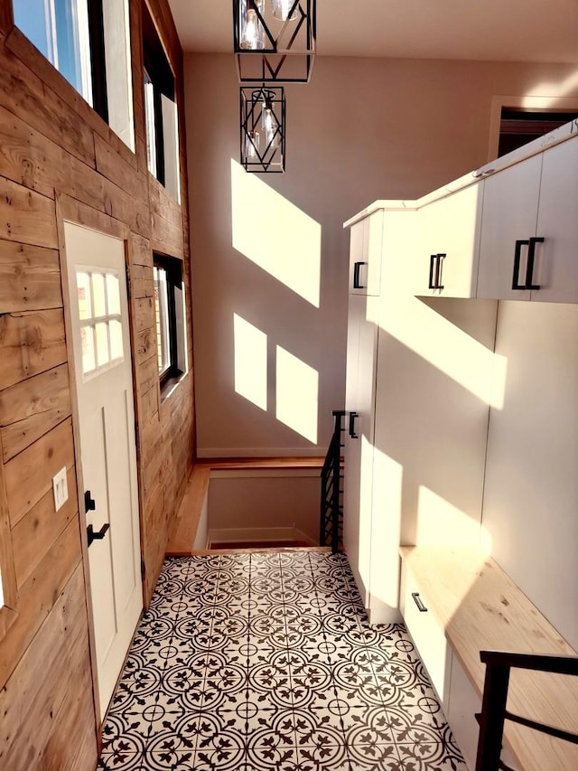 interior space with light tile patterned floors and wood walls