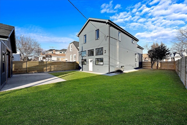 rear view of property featuring central AC unit, a patio, and a lawn