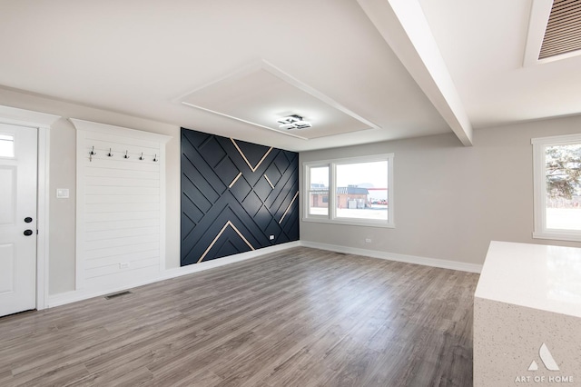 interior space with hardwood / wood-style floors, a wealth of natural light, and beam ceiling