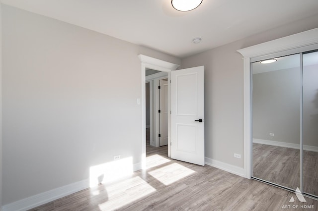 unfurnished bedroom featuring a closet and light hardwood / wood-style flooring