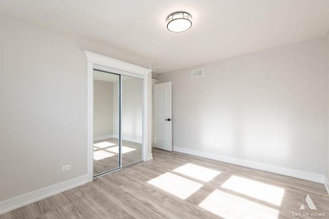 unfurnished bedroom with light hardwood / wood-style floors and a closet