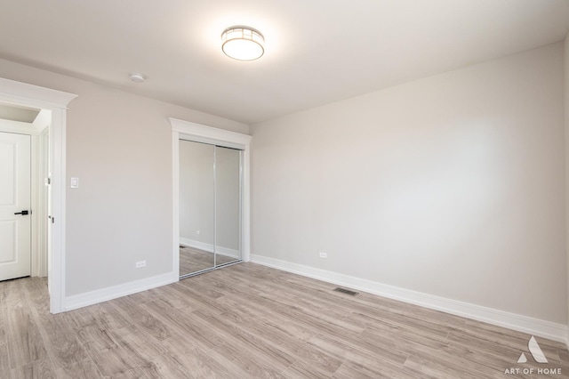 unfurnished bedroom with light wood-type flooring and a closet