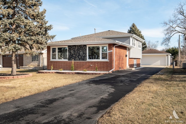 view of front of house featuring a garage, an outdoor structure, and a front lawn