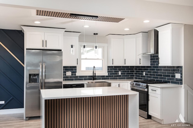 kitchen with wall chimney exhaust hood, sink, decorative light fixtures, a center island, and stainless steel appliances