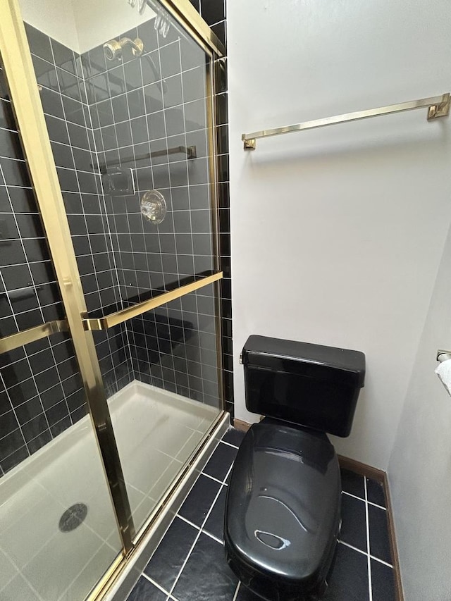 bathroom with toilet, tile patterned floors, and walk in shower