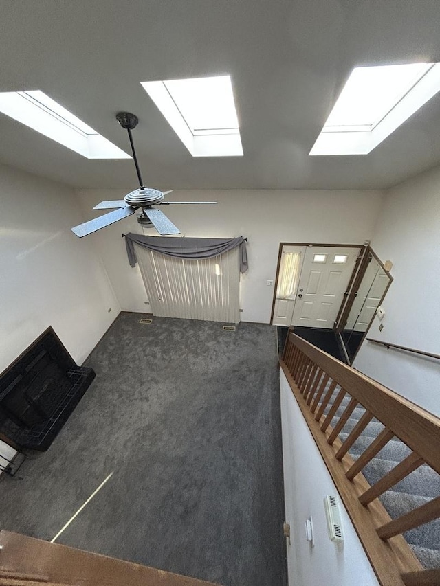 interior space with dark carpet, vaulted ceiling, and ceiling fan