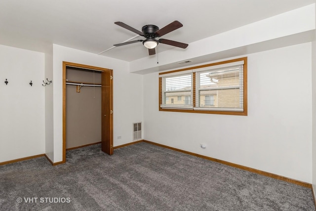 unfurnished bedroom with ceiling fan, dark carpet, and a closet