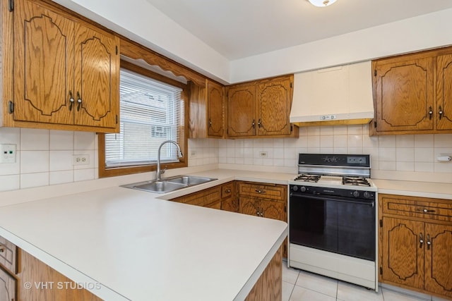 kitchen with sink, light tile patterned floors, premium range hood, tasteful backsplash, and range with gas cooktop