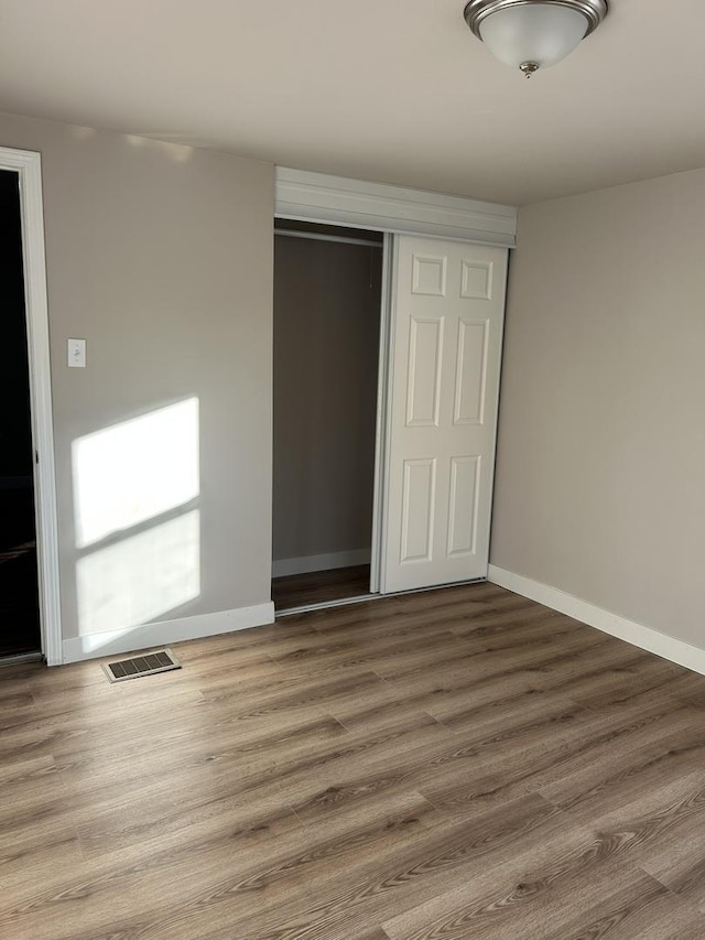 unfurnished bedroom with hardwood / wood-style flooring and a closet