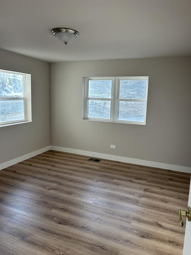 empty room with hardwood / wood-style flooring