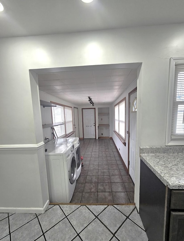 laundry room featuring track lighting, separate washer and dryer, and dark tile patterned floors