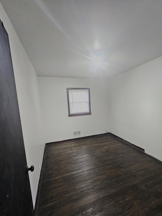 unfurnished room with dark hardwood / wood-style flooring