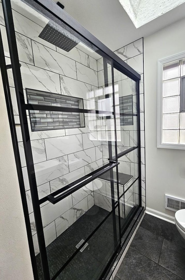 interior space with tiled shower and toilet