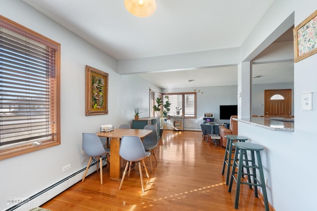 dining space with hardwood / wood-style floors and a baseboard radiator