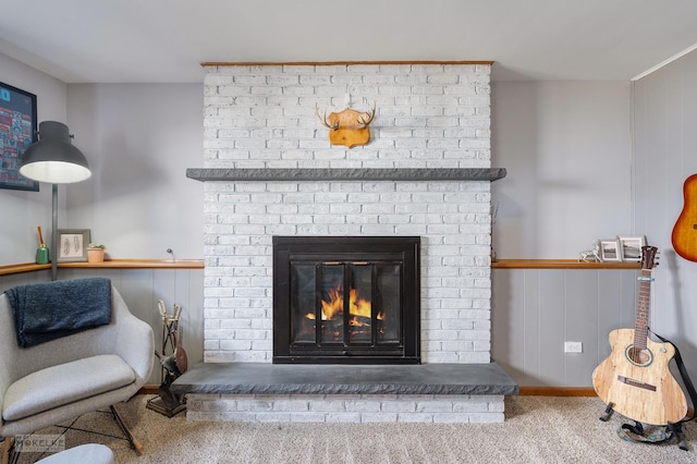 interior details with a brick fireplace and carpet flooring