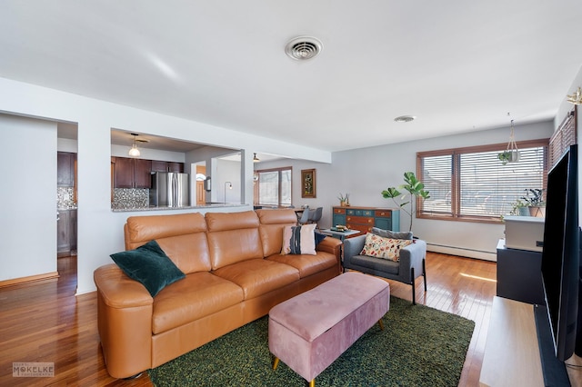 living room featuring a baseboard radiator and hardwood / wood-style floors