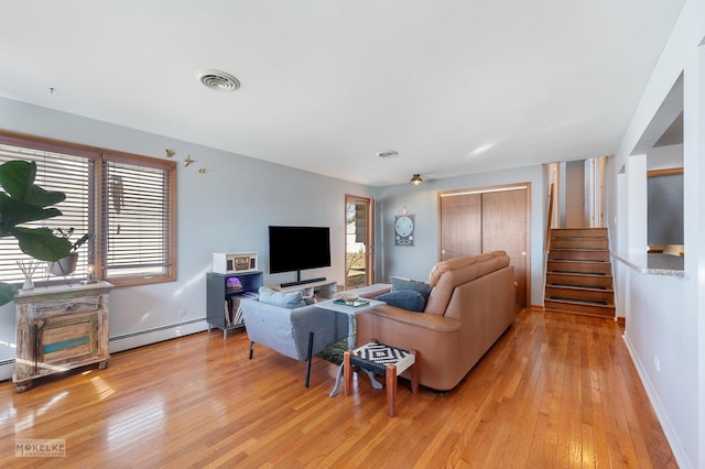 living room featuring baseboard heating and light wood-type flooring