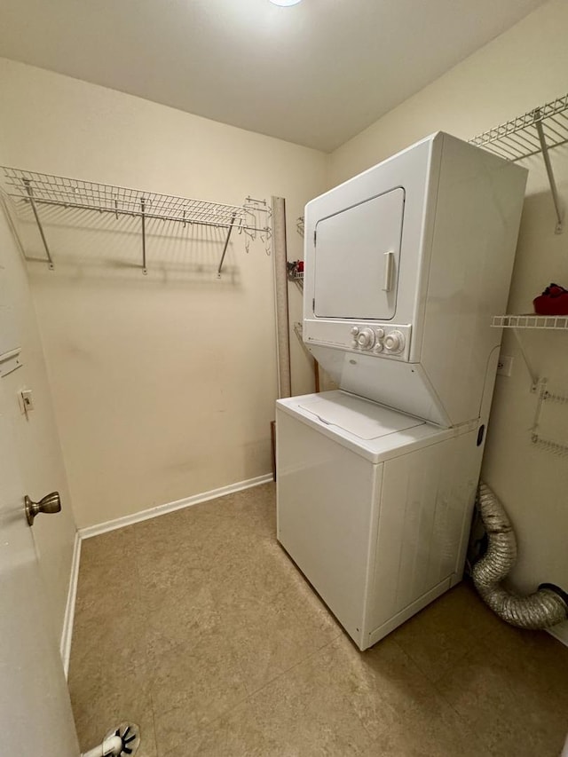 clothes washing area with stacked washing maching and dryer