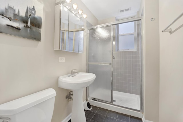 bathroom featuring tile patterned flooring, an enclosed shower, and toilet