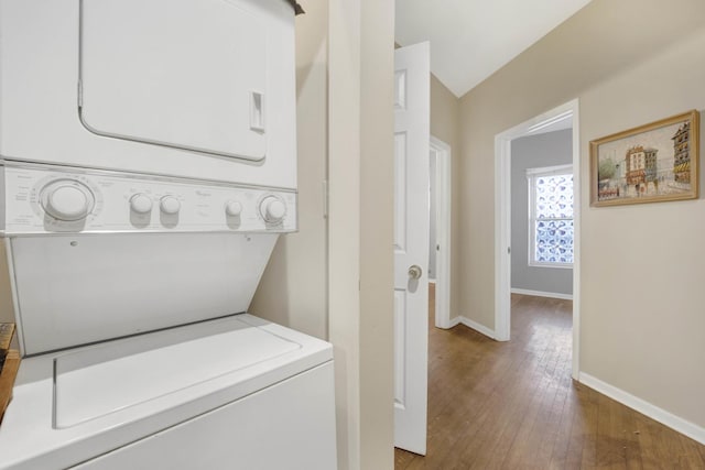 laundry area with stacked washer and dryer and hardwood / wood-style floors