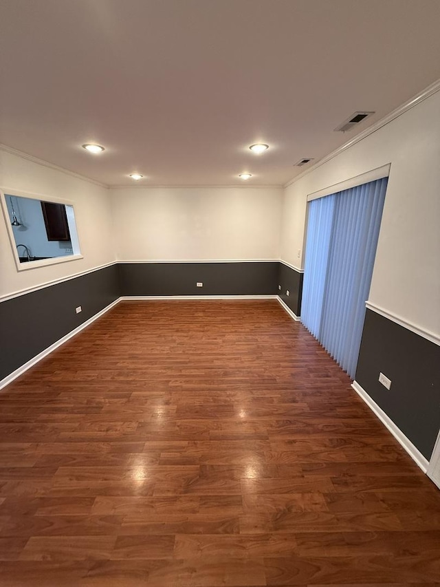 empty room featuring dark wood-type flooring and ornamental molding